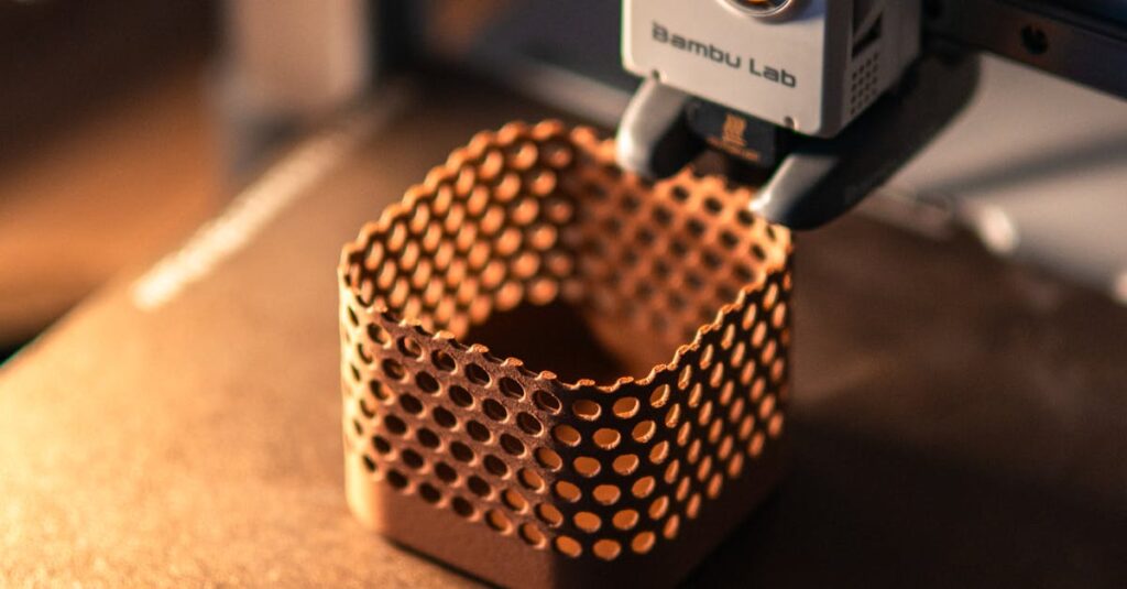 Close-up of a 3D printer creating a hexagonal object in a dimly lit workspace.