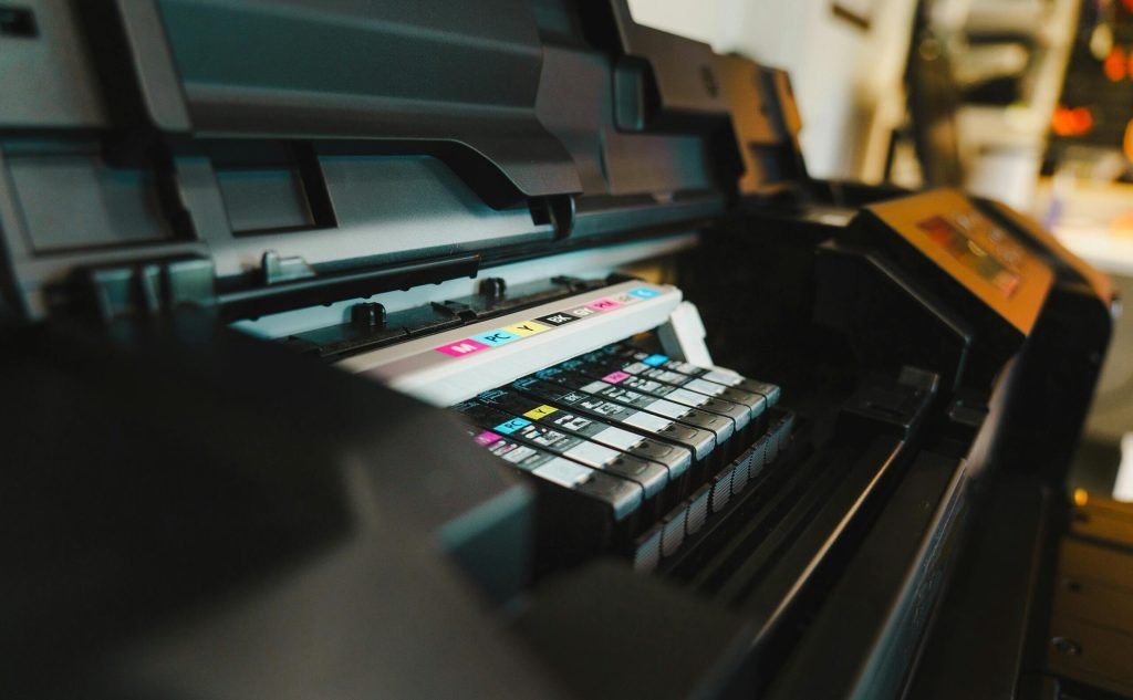 Detailed view of ink cartridges inside a digital inkjet printer in an office setting.